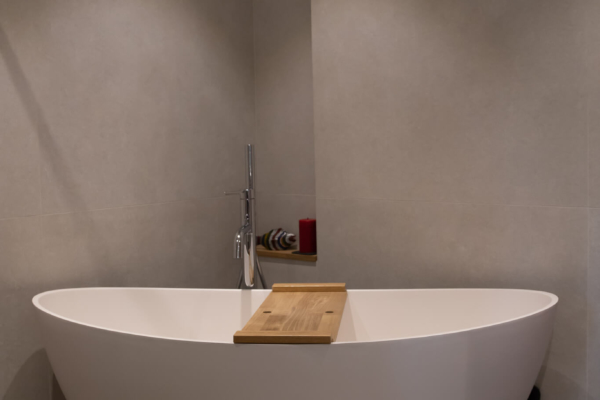 Carrelage et baignoire dans une salle de bain rénovée. Carrelage grand format sur les murs