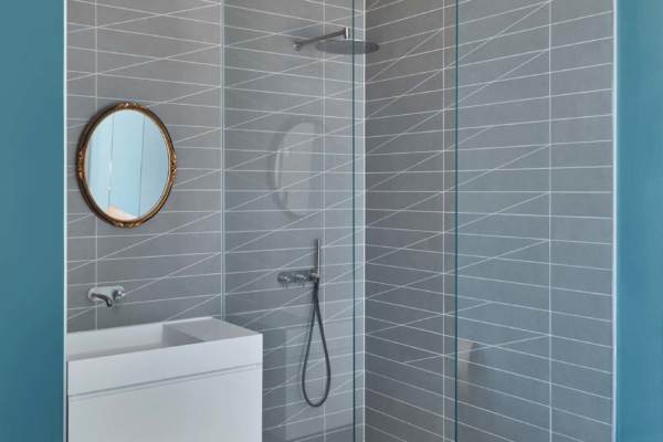 Douche italienne avec carrelage et bois dans une salle de bain moderne. Carreaux avec découpe design
