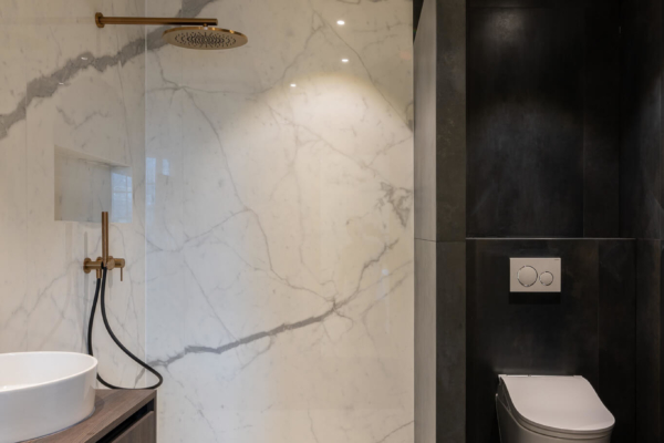 Salle de bains rénovée avec carrelage imitation marbre blanc et carrelage anthracite
