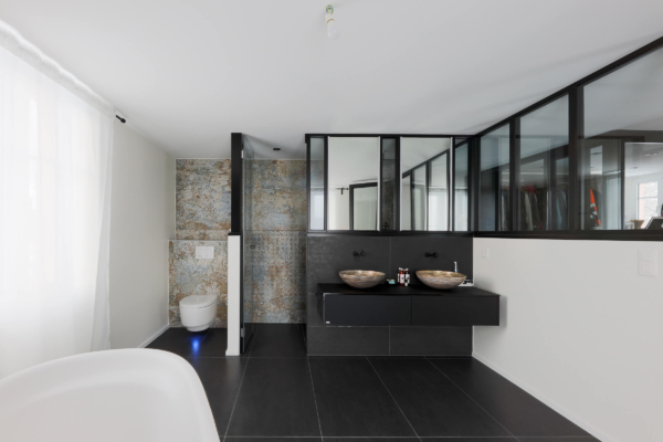 Salle bains avec un sol en carrelage noir et un carrelage à motif au mur lumière éteinte