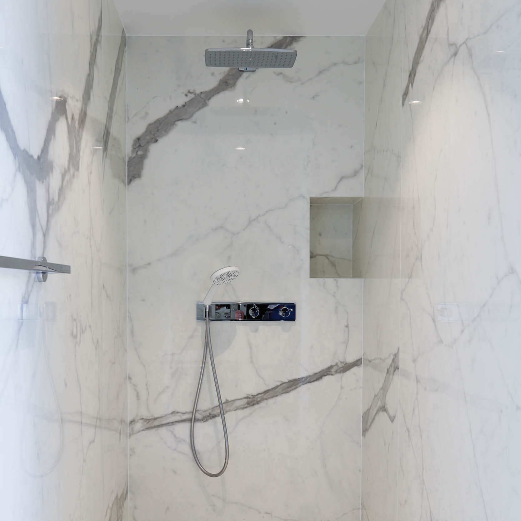 Douche italienne avec carrelage en imitation marbre calacata. 