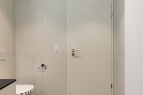 Porte de salle de bains avec carrelage imitation pierre noir au sol et carrelage imitation beton gris