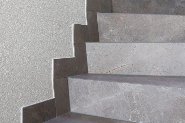 Détail d'escalier avec carrelage gris imitation pierre